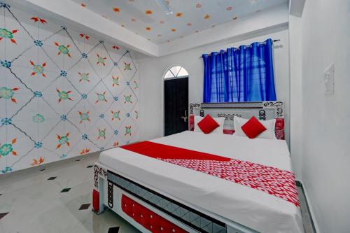 um quarto com uma cama com almofadas vermelhas em OYO Flagship Hotel S Square Guest House em Patna