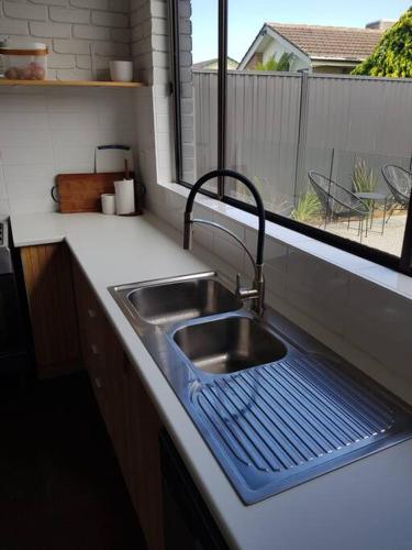 a kitchen sink with a blue mat next to a window at Perfect Large Multi Family Accommodation in Yarrawonga