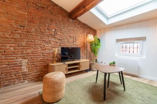 un salon avec un mur de briques dans l'établissement Pretty haven of peace in Saint-Cyprien, à Toulouse