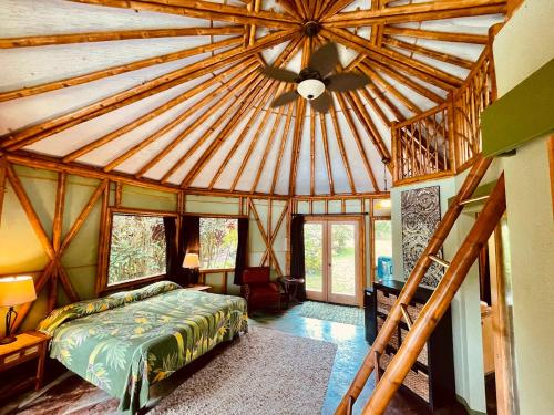 a bedroom with a large wooden ceiling with a bed at Kalani Oceanside Retreat in Pahoa