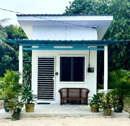 a bench sitting on the front porch of a house at Studio Homestay in Sungai Buluh