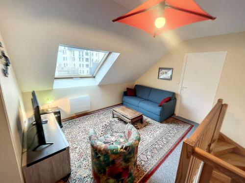 un salon avec un canapé bleu et une fenêtre dans l'établissement Grand duplex en centre-ville avec vue, à 50m de la plage, ascenseur, et WIFI - FR-1-361-165, à Granville