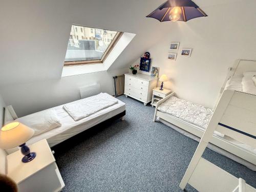 une petite chambre avec deux lits et une fenêtre dans l'établissement Grand duplex en centre-ville avec vue, à 50m de la plage, ascenseur, et WIFI - FR-1-361-165, à Granville