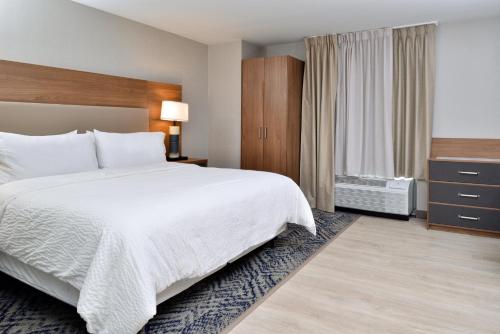a hotel room with a large bed and a window at Candlewood Suites - Joliet Southwest by IHG in Joliet