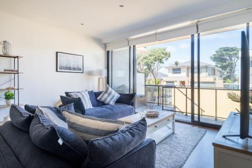 a living room with two couches and a large window at Capel Sound Family Comforts on the Foreshore in Rosebud