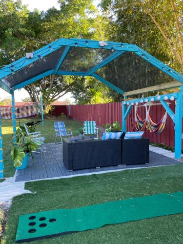 a blue pergola with a couch and a table at Backyard Oasis in Port Saint Lucie
