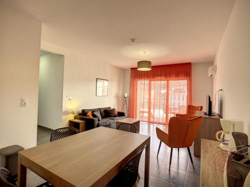 un salon avec une table et un canapé dans l'établissement Appartement F2 climatisé avec parking, Wi-Fi, animaux acceptés, proche centre et Thermes - FR-1-451-113, à Lamalou-les-Bains