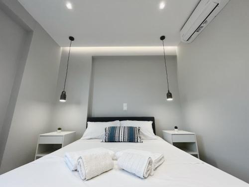 a bedroom with a white bed with two night stands at BlueLine apartment 1 in Loutraki