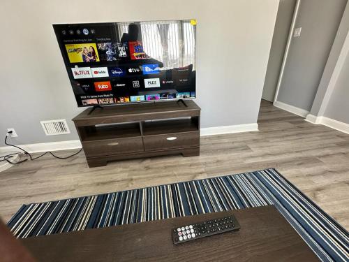 uma televisão numa sala de estar com controlo remoto em Spotless 2 Bedroom Suite in Winnipeg em Winnipeg