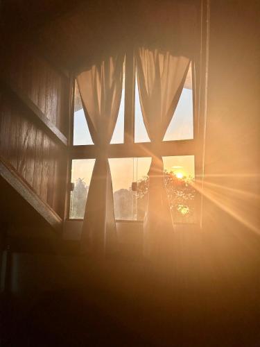 a window with the sun shining through the curtains at Vila Ypáwa 150 m centro 30 m praia lago verde in Alter do Chao
