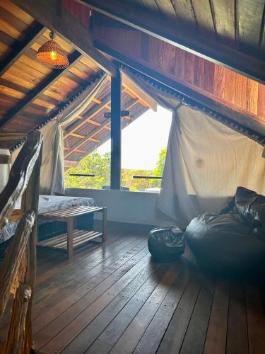 a room with a bed and a table and a window at Vila Ypáwa 150 m centro 30 m praia lago verde in Alter do Chao