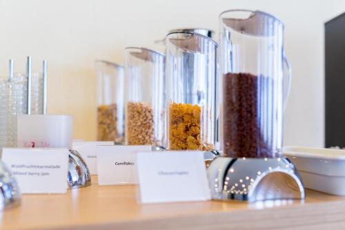 a table with four glass containers filled with food at mk hotel remscheid in Remscheid