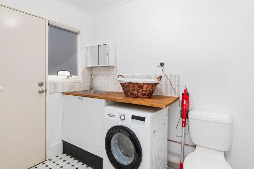 a laundry room with a washing machine and a sink at 3 Redman Place in Soldiers Point