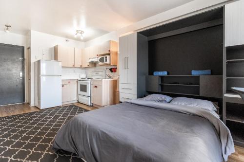 Il comprend une chambre avec un grand lit et une cuisine. dans l'établissement Studio apartment near Downtown - 103, à Montréal