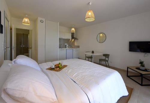 LinguizzettaにあるResidence Marina di Bravoneのベッドルーム1室(白いベッド1台、フルーツトレイ付)