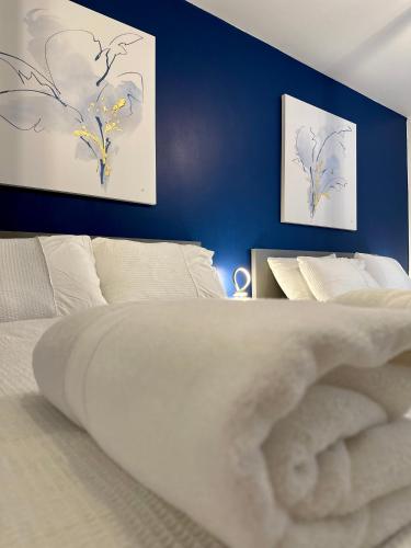 a bedroom with a white bed and blue walls at Stylish Leeds City Apartment in Headingley
