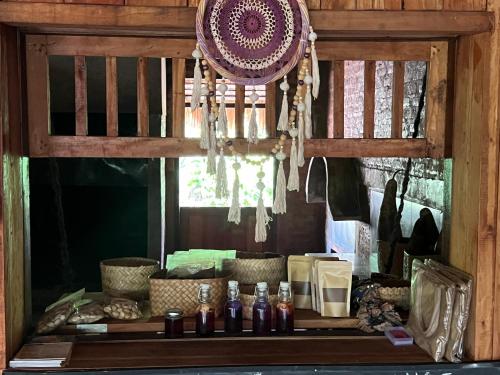 una camera con tavolo, bottiglie e finestra di Sten Lodge eco Homestay a Labuan Bajo