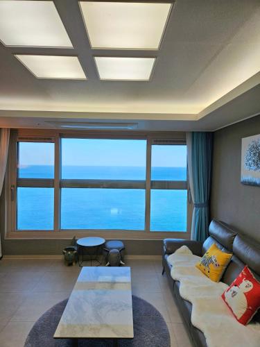 a living room with a couch and a table at 이스턴뷰 프리미엄 레지던스 100프로오션뷰 in Ulsan