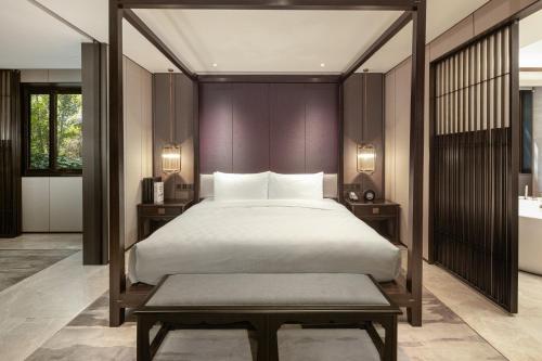a bedroom with a large bed with a wooden headboard at HUALUXE Xi'an Tanghua by IHG in Xi'an