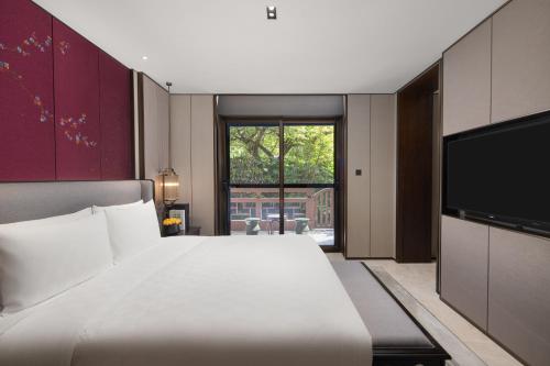 a bedroom with a large bed and a flat screen tv at HUALUXE Xi'an Tanghua by IHG in Xi'an