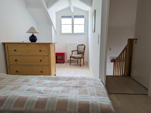 une chambre avec un lit, une commode et une chaise dans l'établissement Arcachon Centre: Beau Duplex T3 3* avec Balcon, Parking, à deux pas de la Plage et des Commerces - FR-1-420-107, à Arcachon