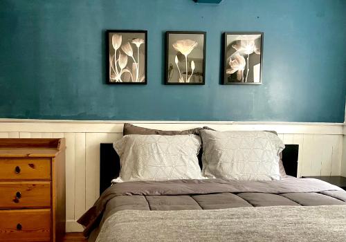 a bedroom with four pictures on a blue wall at heart of Kitsilano area,5 mins walk to kits beach in Vancouver