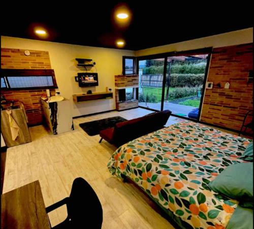 a bedroom with a bed and a living room at Carmesí Smart Glamping in Simijaca