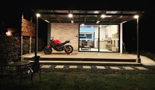 ein Motorrad, das nachts in einer Garage parkt in der Unterkunft Carmesí Smart Glamping in Simijaca