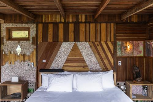 a bedroom with a bed with a wooden wall at Mamallacta Páramo Lodge in Papallacta