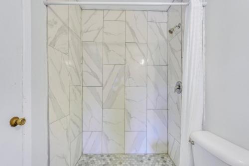 a bathroom with a shower with white tiles at Atlantis Inn - Tybee Island in Tybee Island