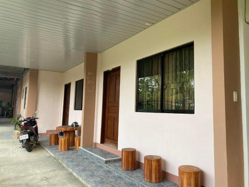 a motorcycle parked next to a building with wooden stools at Merangie Travellers Inn in Dauis