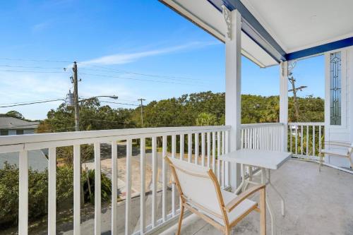 a white porch with a table and a chair at Atlantis Inn - Tybee Island in Tybee Island