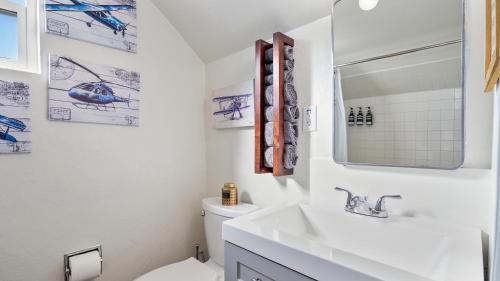 a white bathroom with a sink and a toilet at Midtown Flight Deck: 2BR Gem in Reno