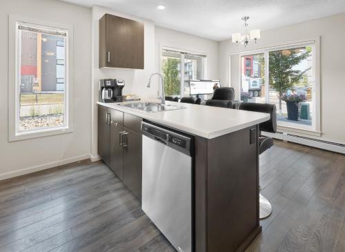 a kitchen with a sink and a dishwasher at 5 STAR Business Luxury Homeshare in Edmonton