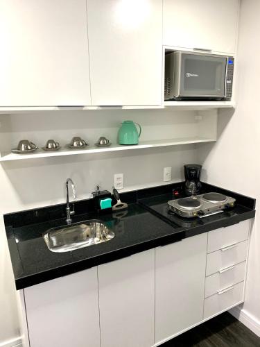 a kitchen with a sink and a microwave at Flat Hotel de luxo em Moema, São Paulo in São Paulo