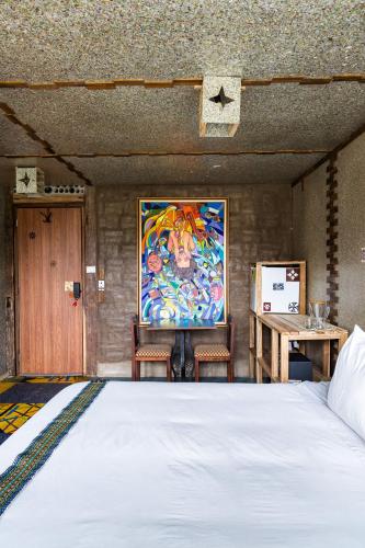 a bedroom with a bed and a painting on the wall at Mamallacta Páramo Lodge in Papallacta