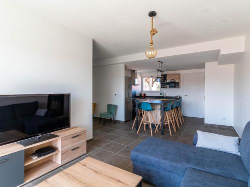 un salon avec un canapé bleu et une télévision dans l'établissement Appartement 3* à 50m de l'Océan, 5 pers, Clim, Wifi, Parking - Mimizan Plage - FR-1-50-116, à Mimizan