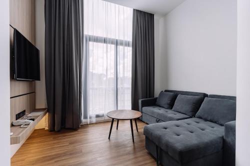a living room with a couch and a table at Impiana by Roxy Hotel in Kuching