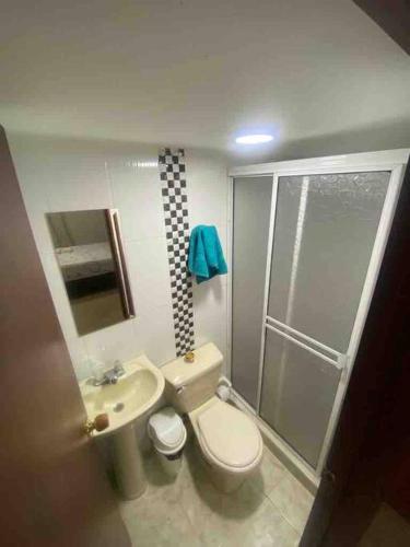 a bathroom with a toilet and a sink and a shower at Apartaestudio privado con aire cerca Aeropuerto in Cali