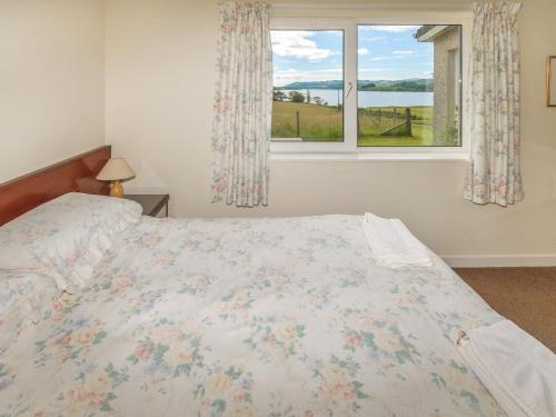 a bedroom with a bed and a window at Barr Beithe Lower in Dallavich
