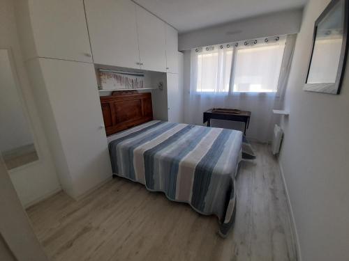 une chambre avec un lit avec une couverture rayée dans l'établissement Appartement T2 à Arcachon - Proche du Casino, Centre-ville, Plage d'Eyrac, Parking et Balcon - FR-1-319-510, à Arcachon