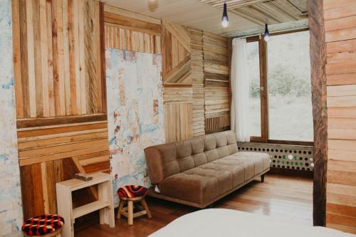 a living room with a couch in a room with wooden walls at Mamallacta Páramo Lodge in Papallacta