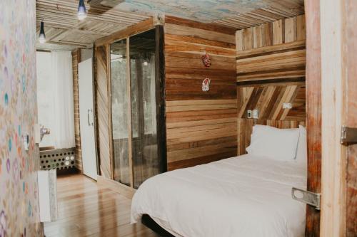 a bedroom with wooden walls and a bed in a room at Mamallacta Páramo Lodge in Papallacta