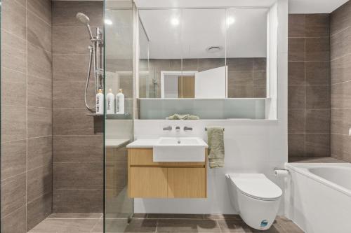 Un baño con lavabo, inodoro y ducha. en Splash by Experience Jervis Bay, en Huskisson