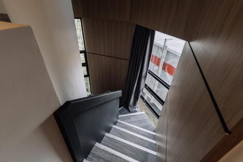 a staircase in a house with a black railing at Impiana by Roxy Hotel in Kuching