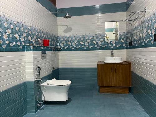 a blue and white bathroom with a toilet and a sink at Earth Lounge Resort in Vagamon