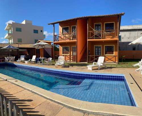 a villa with a swimming pool in front of a house at Águas de Sauípe in Porto de Sauipe