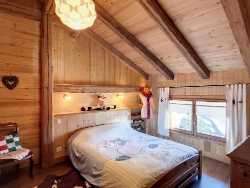une chambre avec un lit dans une pièce en bois dans l'établissement Appartement dans Ferme Authentique à Cordon - Parking, Wifi, 2 à 4 mois Hiver, 15 jours Eté - FR-1-560-109, à Cordon