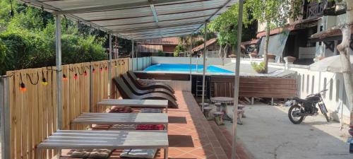 a swimming pool with benches and a hot tub at Vongprachan Backpackers Hostel in Luang Prabang