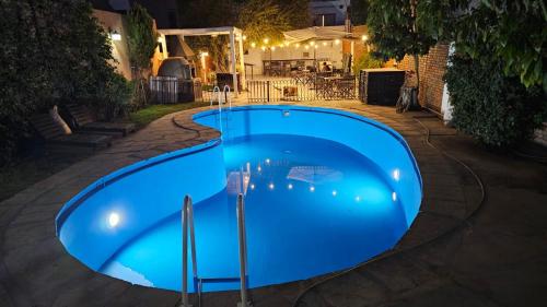 a large blue swimming pool at night at Hotel Namaste in Mendoza